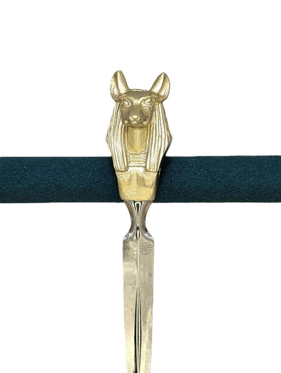 Abrecartas de estaño con la imagen del dios egipcio Anubis.